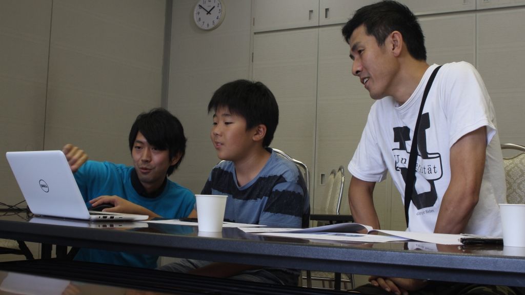 男性メンターが親子に指導している姿