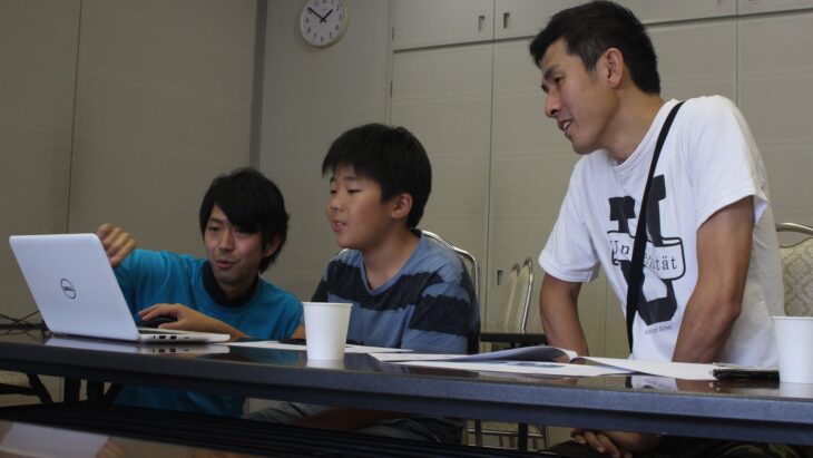 男性メンターが親子に指導している姿