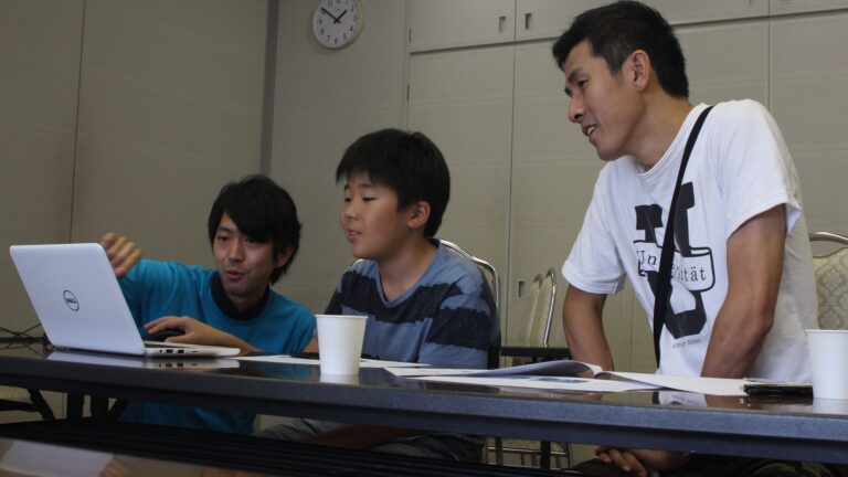 男性メンターが親子に指導している姿